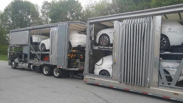 Two car carriers parked with loaded vehicles