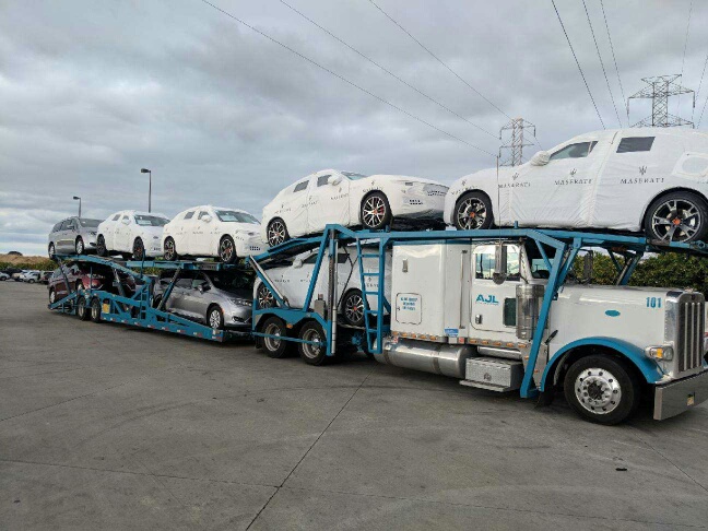 AJL-branded car carrier hauling Maserati vehicles